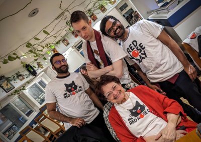 Four people in Red Nose Day garb.